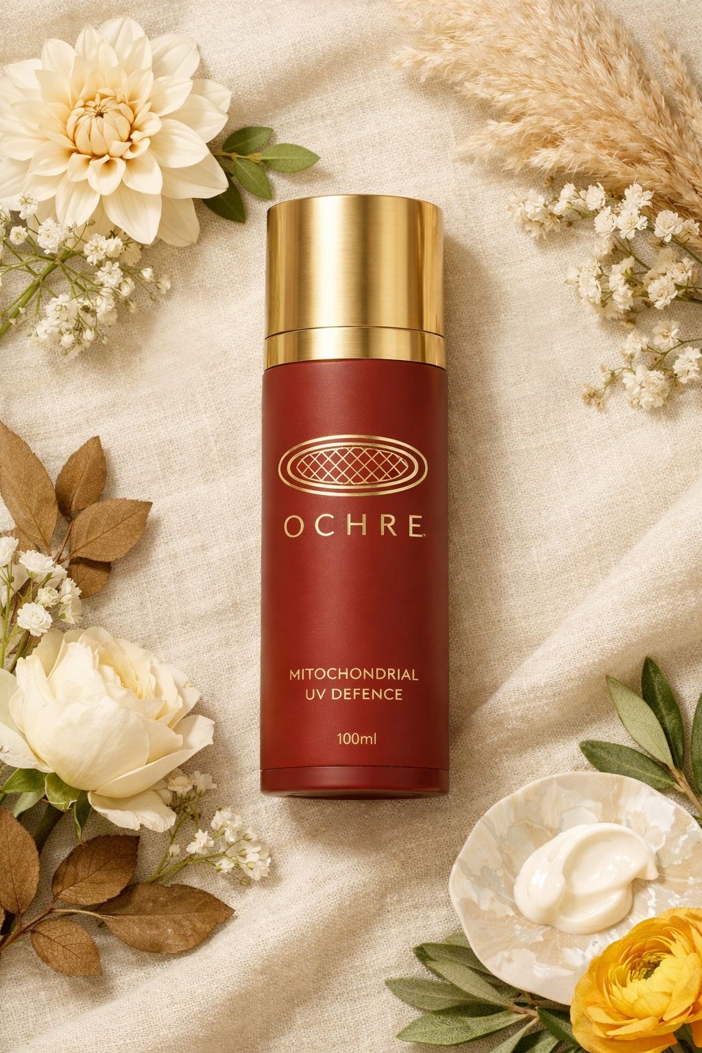 OCHRE flat lay editorial — airless dispenser with ochre stones and botanical sprigs